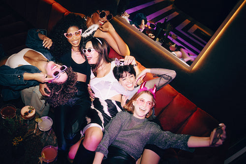 Group of friends enjoying a lively party in a nightclub setting