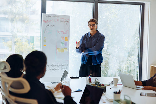 Man presents UX plan to team with whiteboard
