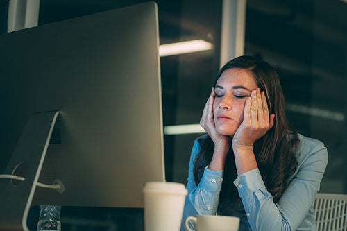 Woman entrepreneur sitting in office looking tired