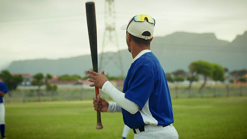 Player swings the bat and hits the baseball during practice with precision.