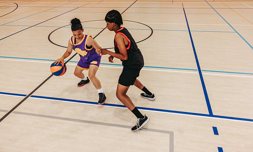 Speed and agility: Woman dribbling past defender in a fast break