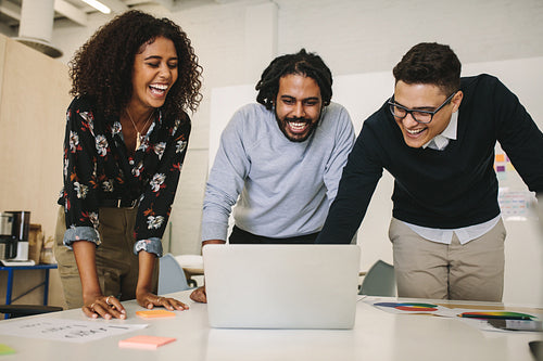 Business partners laughing looking at a laptop computer