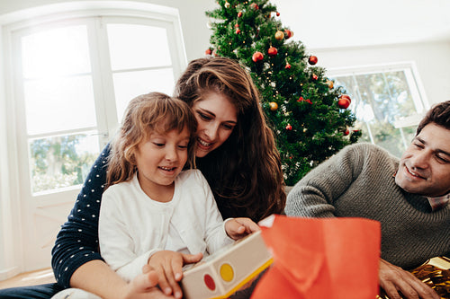 Little girl having  a look at her Christmas gift.
