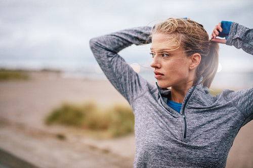 Female runner tying up hair before a run