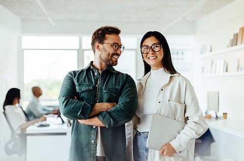 Two business people standing together in an office