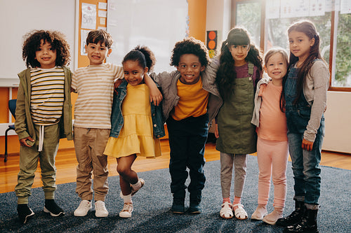 Group of diverse primary school children standing together and looking at the camera