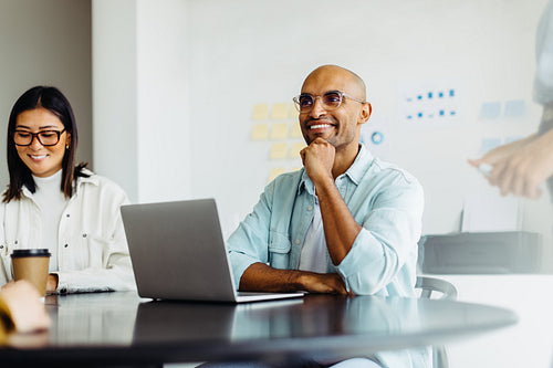 Business man listening to a discussion during a meeting with his team