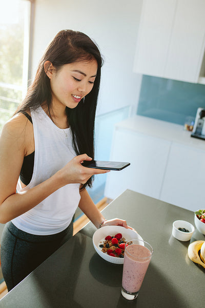 Chinese woman capturing photos of a healthy breakfast