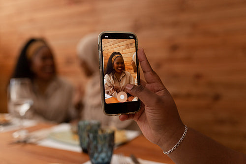 Woman taking a picture of her friends in a restaurant