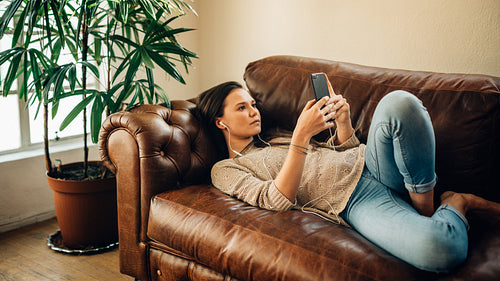 Woman relaxing at home with her phone