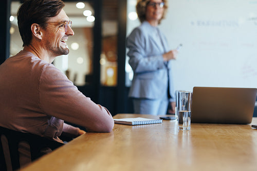 Happy business man sitting in a boardroom meeting with his team