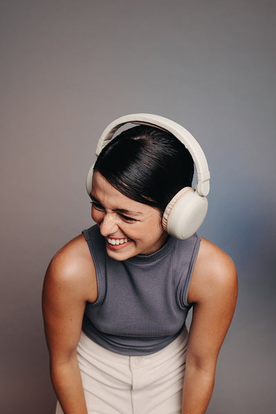 Cheerful young woman laughing while wearing headphones