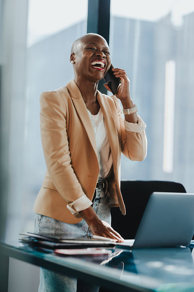 African businesswoman discussing success with a colleague at the office