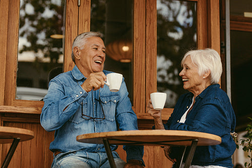 Smiling senior couple drinking coffee in cafe