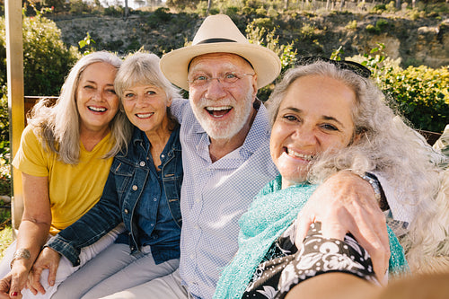 Excited senior friends taking a selfie together during vacation