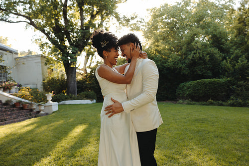 Bride and groom enjoying a joyful moment outdoors on their wedding day
