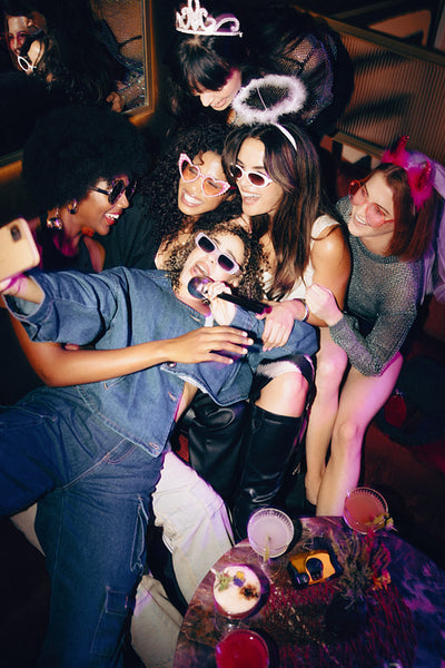 Group of young women enjoying a fun night out singing and celebrating