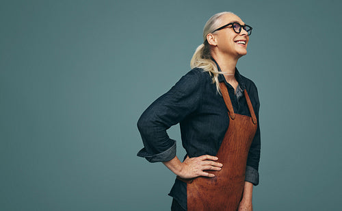 Cheerful female goldsmith laughing in a studio