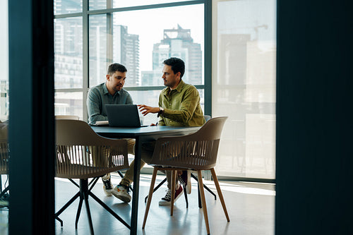 Two men discussing project ideas in a modern office environment