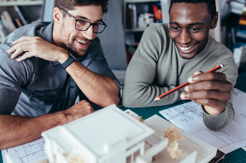 Two architects working on a building model