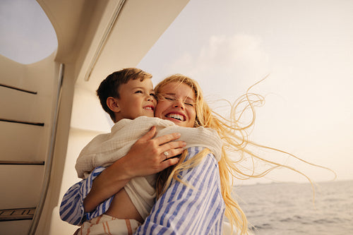 Mother and child enjoying a joyful vacation on a boat with the ocean in the background