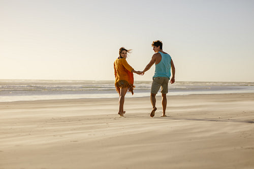 Couple walking on beach holding hands