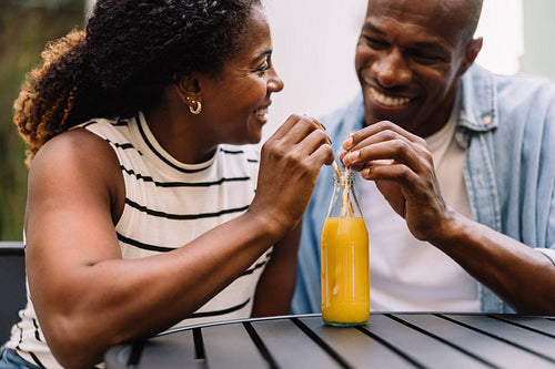 Joyful black couple smiling and having fun with a drink