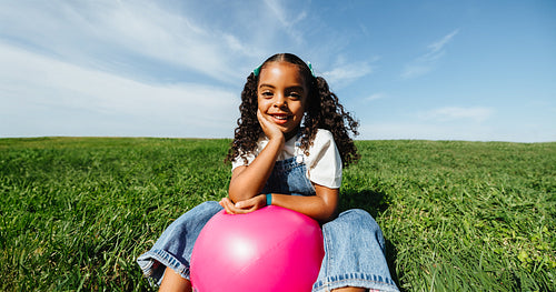 Girl relaxing in open field during cheerful outdoor play