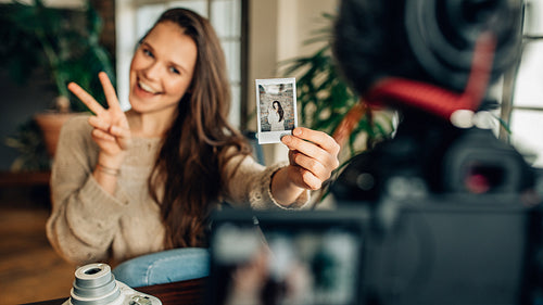 Young female blogger showing off her instant photo