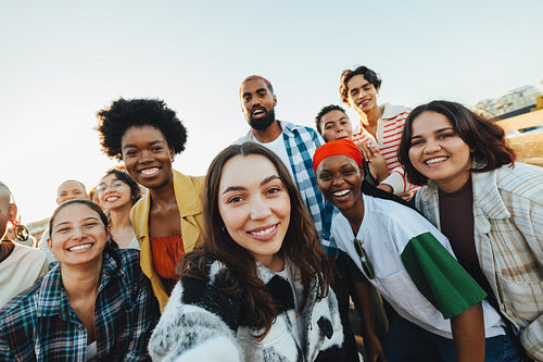 Diverse group of friends gathering outdoors while expressing unity and happiness