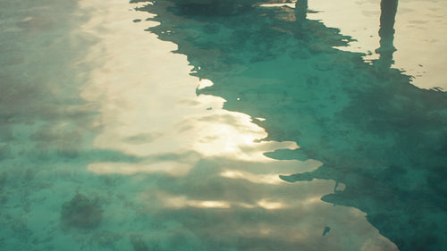 Golden sunlight reflecting on the clear turquoise water of the ocean in the morning
