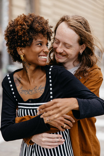 Embracing couple sharing a joyful moment on city streets