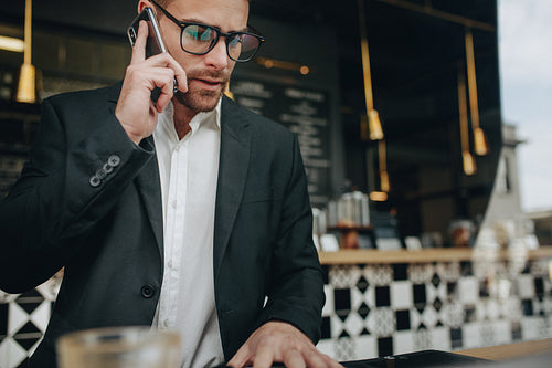 Businessman at a restaurant talking over mobile phone