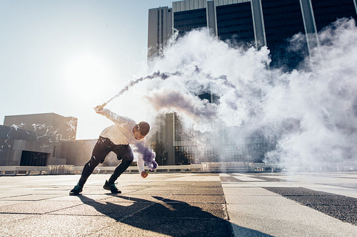 Man practicing free running with smoke grenade