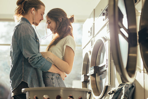 Couple standing in a laundry room holding each other