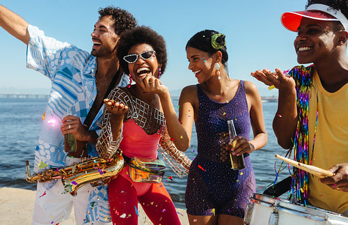 Group of friends celebrate on sunny beach carnival