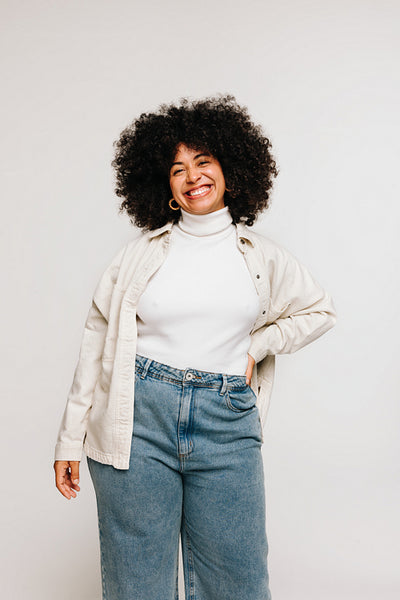 Self-confident woman with Afro hair smiling at the camera in a studio