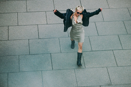 Top-down view: woman walking alone across city pavement