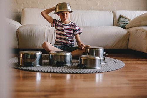 Future drummer boy with cooking pots at home