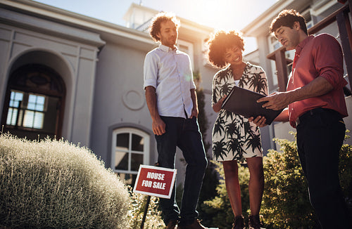Home buyers with broker going through paper work