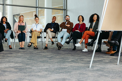 Diverse group of people attending a business conference in a modern office setting