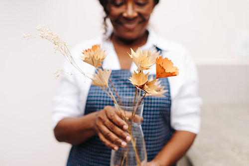 Female florist holding a bouquet of handmade floral craft