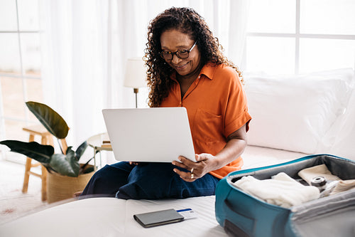 Mature woman using a laptop, making travel arrangements online