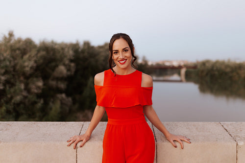 Cheerful young woman standing on a bridge outdoors