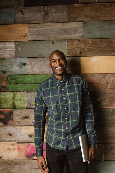 Portrait of happy young man against wooden wall