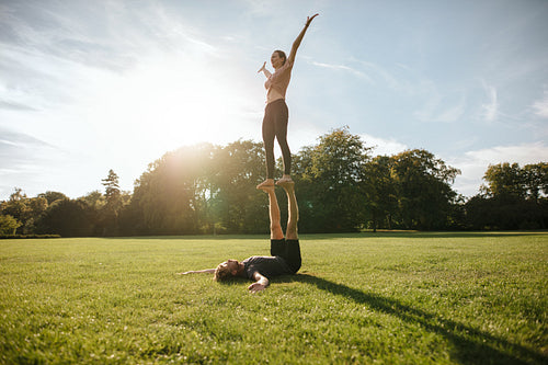 Couple doing acrobatic yoga exercise at park