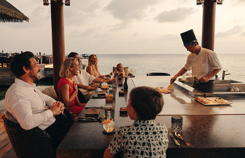 Family enjoying a teppanyaki dining experience at a seaside restaurant resort