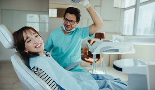 Confident girl smiles during friendly dental checkup at clinic