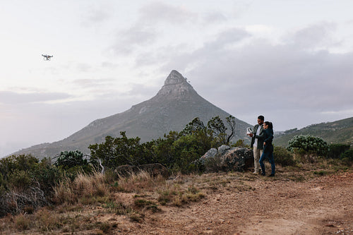 Young couple guiding a drone through a remote control
