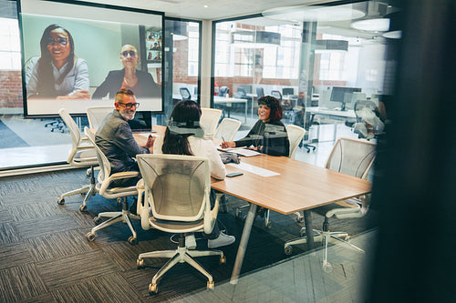Smiling businesspeople having a virtual meeting with their associates